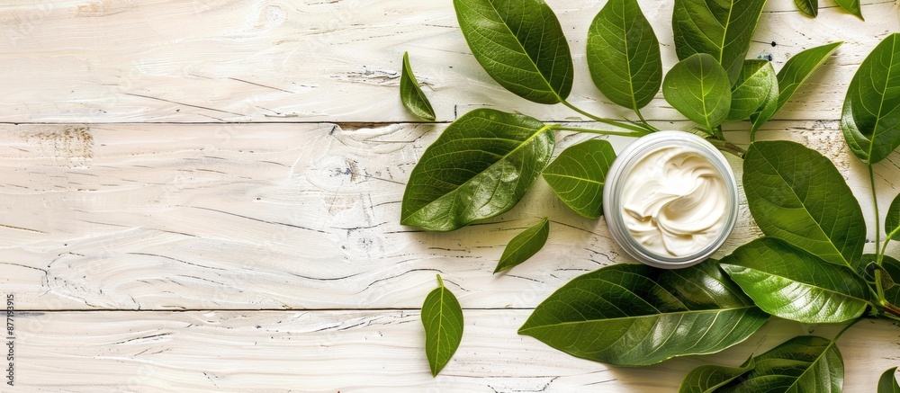 Aufkleber Cosmetic cream placed on a fresh herbal leaf with a white wood background creating an elegant composition with copy space image