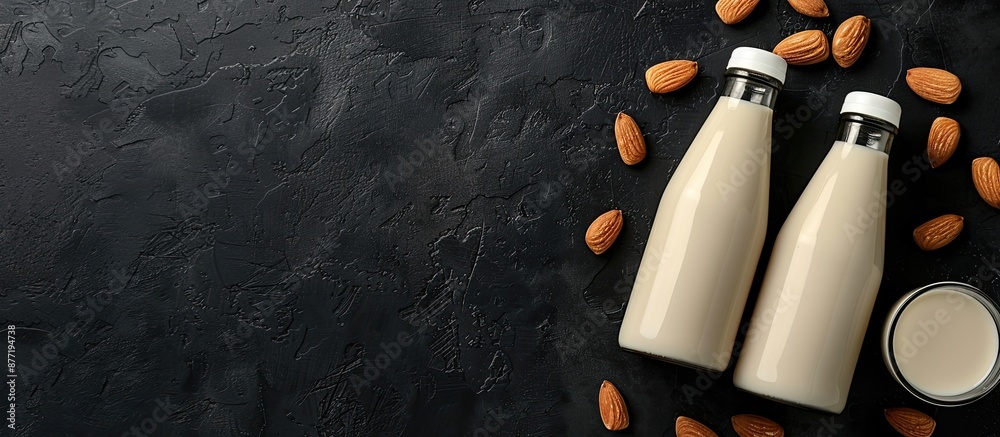 Poster dark black table displaying two bottles of almond milk with nuts a sugar free lactose free vegetaria