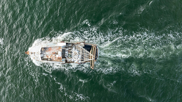 Aerial view of trawler vessel. Fishing boat trauler with sacks full of rapani