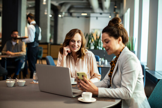 Diverse businesswomen having meeting in hotel restaurant