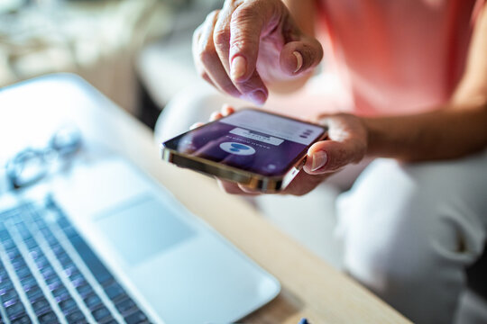 Close up of a middle aged woman holding smartphone with bank app