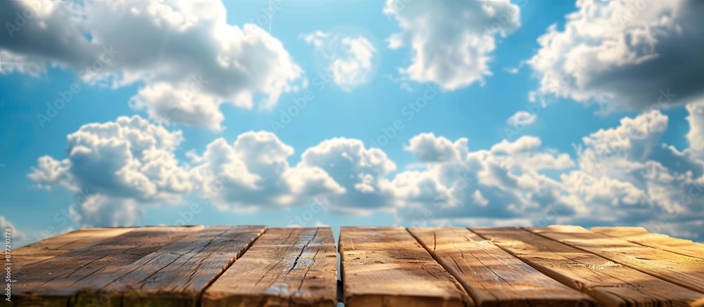 Poster focused on an empty brown wooden table against a blurred blue sky background with bokeh effects perf