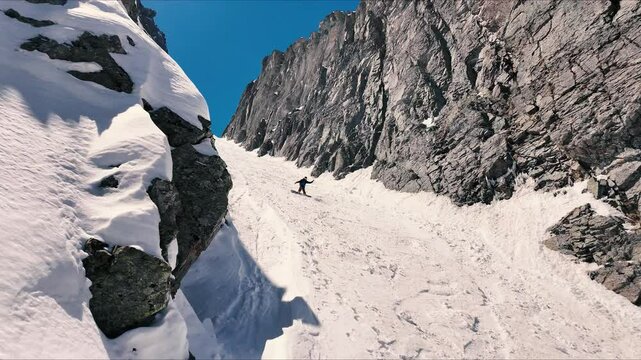 Splitboarder slow motion coming through chute