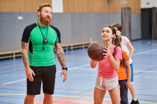 A man stands next to a girl, holding a basketball in his hand in a dynamic and engaging moment.