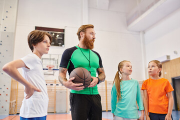 Obraz premium A man holding a basketball in front of a group of diverse, enthusiastic kids in a bright classroom setting, teaching and inspiring them.