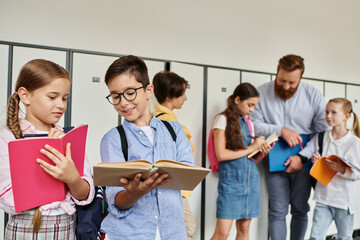 A man teacher is instructing a diverse group of school children standing in a bright hallway, engaging in lively interactions and learning moments.