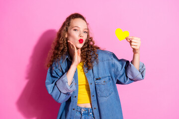 Photo of shiny attractive lady dressed denim jacket showing yellow heart lips pouted empty space isolated pink color background