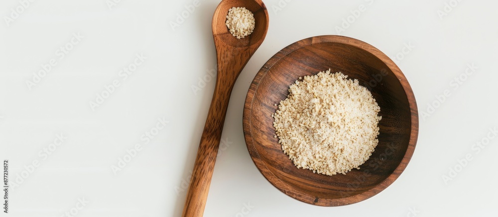 Fototapete a wooden spoon and a bowl holding dry yeast are placed on a white background the image is in a horiz