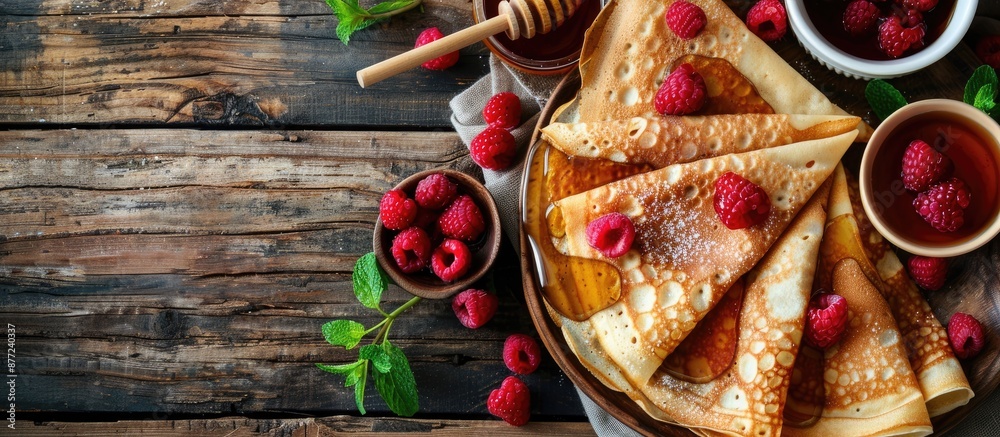 Leinwandbilder rural breakfast spread viewed from the top thin crepes or pancakes with raspberries honey and mint o