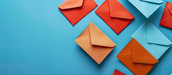 A blue background with orange envelopes containing blank white and blue paper sheets providing a copy space image for your design