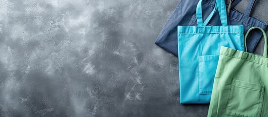Blue and green tote bags are showcased from above on a grey backdrop with ample space for text or images emphasizing a trendy shopping theme