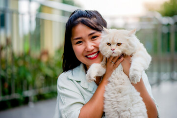 Asian girl takes care of a cat and smiles happily holding his cat every day. Pet lovers, the bond between people and cats