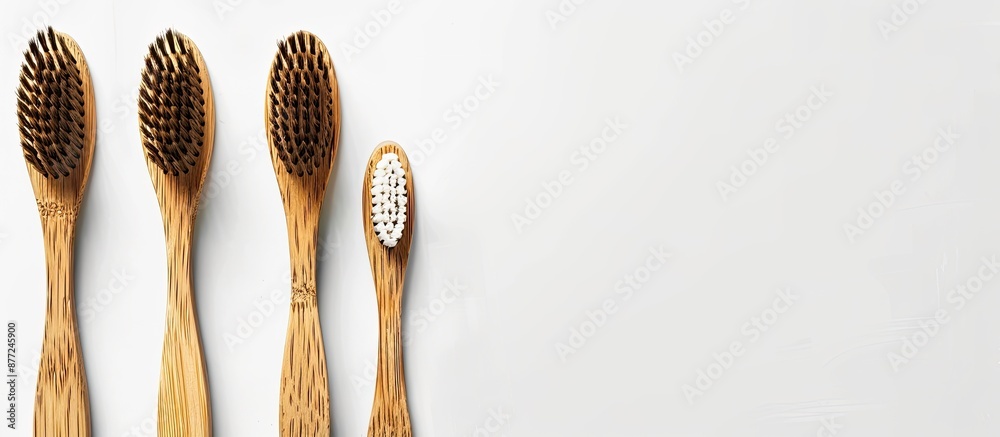 Poster dental care concept featuring three bamboo toothbrushes arranged on a white backdrop from a top view