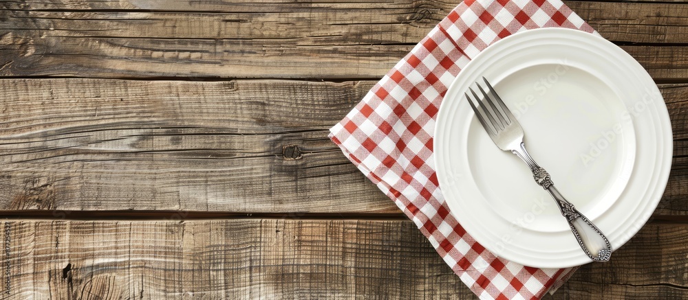 Fototapete a white plate and fork placed on a rustic wooden table with a checkered tablecloth and ample copy sp