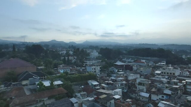 Time lapse footage of moving-clouds go faded and sunlight rises behind mountains. Morning vibrant on highland suburban houses. 
