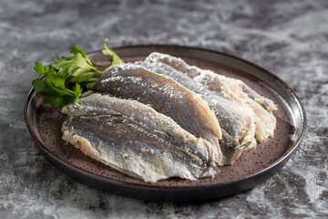 Raw sardine fish seasoned with garlic ready to cook.
