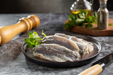 Raw sardine fish seasoned with garlic ready to cook.