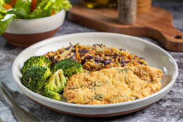 Breaded fried fish with lettuce salad and vegetable salad.