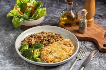 Breaded fried fish with lettuce salad and vegetable salad.