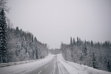 Fototapeta premium winter landscape of a snow-covered road to a remote village, blizzard and frost