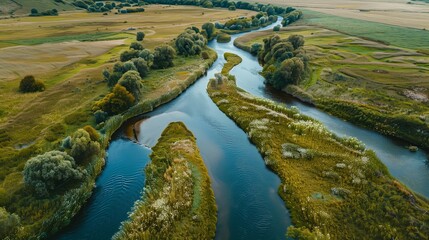 A high definition drone of a meandering river with sandy banks, surrounded by greenery and scattered trees. The scene captures the serene beauty of the natural environment.