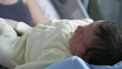 Side View of a Newborn Baby Resting Comfortably, Highlighting Soft Features and Dark Hair in a Calm, Indoor hospital Environment