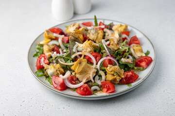 Warm salad with rapan (snails), tomatoes, onions, leafy vegetables and olive oil. Traditional salad with seafood. Close-up, selective focus.