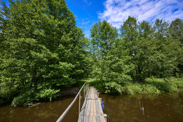 Colorful landscape with a wooden bridge over the river