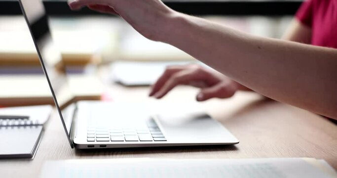 Female manager opens modern laptop to continue typing report. Woman ready to work on electronic device sitting at table in office slow motion