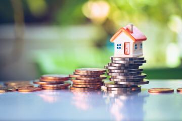 Closeup miniature house on stack coins using as property and financial concept
