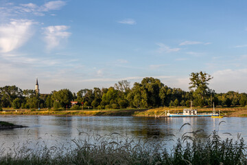 The ferry boat across the river Elbe near Coswig, Germany, departing from rural river landing in the evening