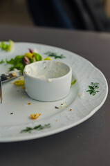 Dirty white plate after eating the meal with small for sauce. High quality photo