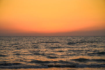 Calming seascape of evening summer beach in resort town