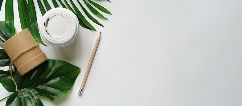 Top down view of an office desk showcasing various office supplies including a pencil a coffee cup and a green leaf on a white background with copy space image