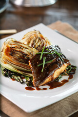  grilled salmon steak garnished with sauce and herbs served