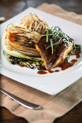  grilled salmon steak garnished with sauce and herbs served