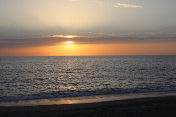 Sunset over the sea on a summer evening on the beach in Calabria