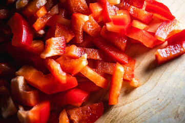 appetizing background of vegetables, sliced ​​red tomatoes and bell peppers on a wooden background, close-up, selective focus