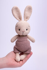 Handmade knitted amigurumi bunny toy on a white background.
