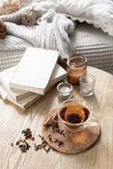 Still life with a cup of tea, books and a candle in a candlestick.