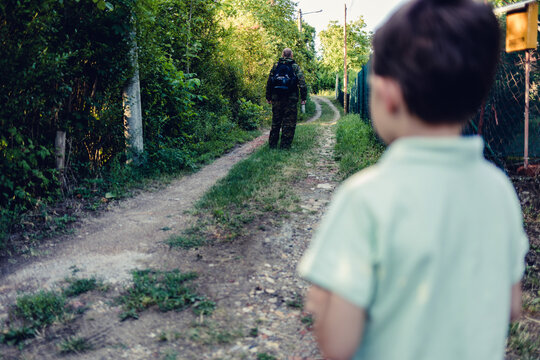 The dad is leaving for overseas assignment. The boy standing in front of the gate and sending his father off on an overseas assignment.