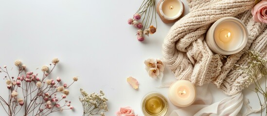 Obraz premium Top down view of a feminine work area featuring a white background adorned with roses candles textiles and decorations ideal for adding text or images. Copy space image