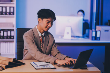Fototapeta premium Modern young man working remotely from home at night.