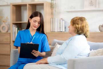 Caregiver sitting on sofa checkup and diagnostic with elderly woman patient about health in living room at home, caretaker sitting on couch explaining and examining senior, insurance and medical.