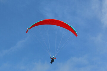 Paraglider flying in a blue sky	