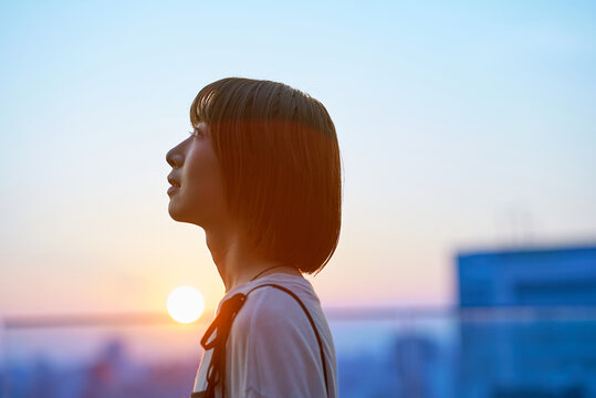 マジックアワーの街に立つ若い女性のポートレート