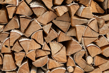 Fototapeta premium Stack of dried firewood from birch wood. Harvesting wood for the winter. Firewood background.