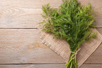 Bunch of fresh dill on wooden table, top view. Space for text