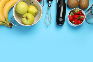 Hand blender kit and fresh fruits on light blue background, flat lay. Space for text