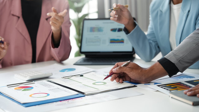 Business team members are using charts and graphs to analyze financial data and performance metrics during a discussion